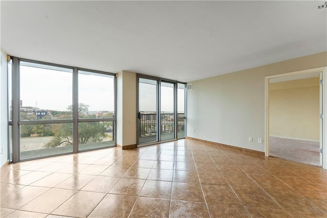 spare room with light tile patterned flooring and floor to ceiling windows