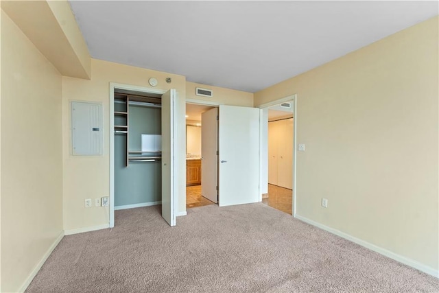 unfurnished bedroom featuring electric panel, carpet floors, a closet, and baseboards