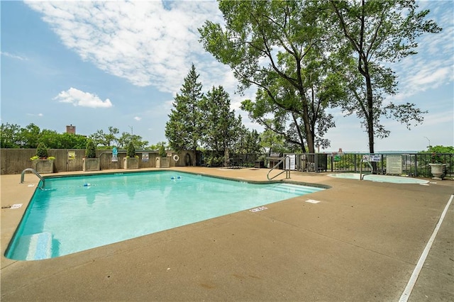 community pool featuring fence and a patio