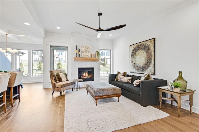 12967 S Constance St, Olathe, KS 66062 - living area featuring a ceiling fan, wood finished floors, recessed lighting, a tiled fireplace, and ornamental molding
