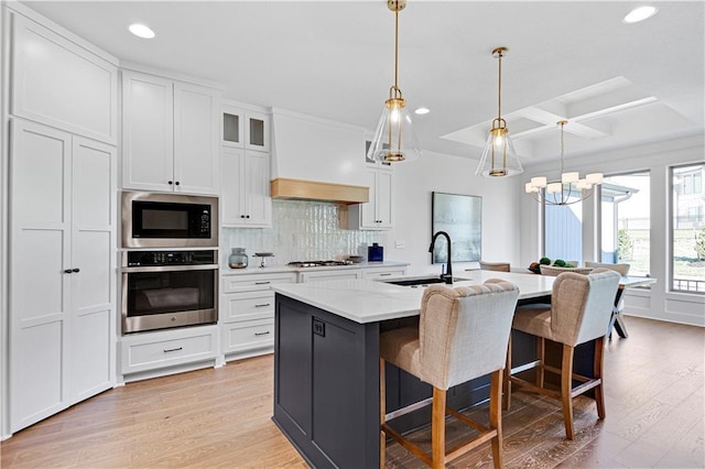 12967 S Constance St, Olathe, KS 66062 - kitchen with appliances with stainless steel finishes, coffered ceiling, custom range hood, recessed lighting, and a chandelier