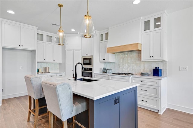 12967 S Constance St, Olathe, KS 66062 - kitchen featuring appliances with stainless steel finishes, recessed lighting, white cabinets, light wood-type flooring, and light stone counters
