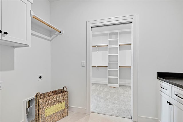 12967 S Constance St, Olathe, KS 66062 - laundry room with hookup for an electric dryer, cabinet space, light tile patterned flooring, and light colored carpet