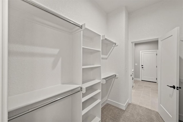 walk in closet with light colored carpet