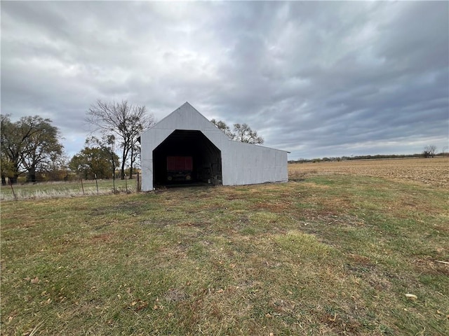 view of outbuilding featuring a lawn and a rural view