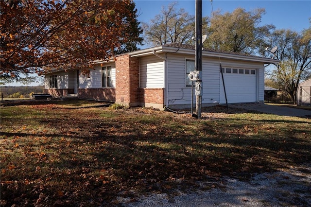 view of side of property featuring a garage and a lawn