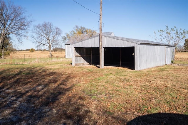 view of outbuilding featuring a yard and a rural view