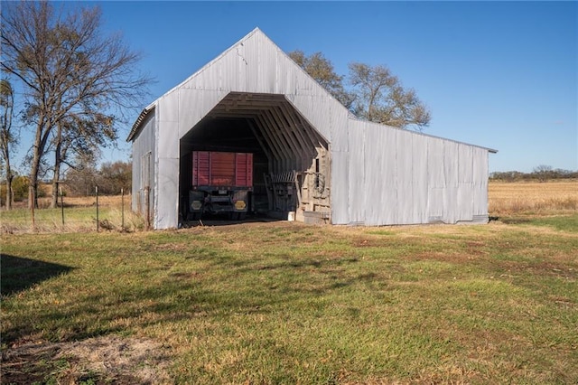 view of outbuilding featuring a lawn and a rural view