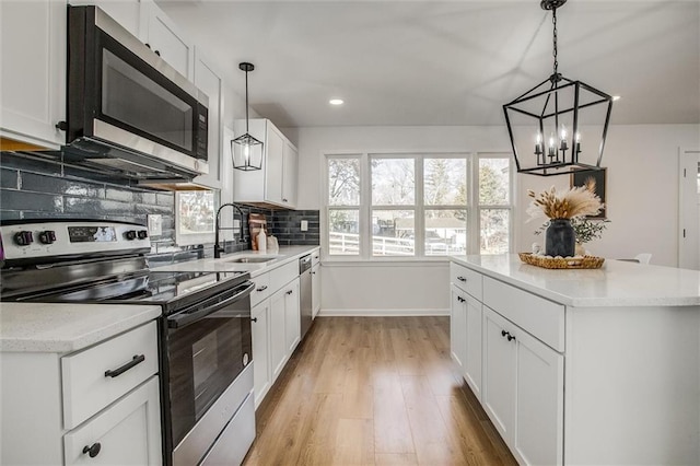 kitchen featuring sink, white cabinets, light wood-type flooring, and appliances with stainless steel finishes