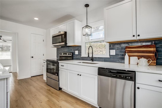 kitchen with white cabinets, appliances with stainless steel finishes, a healthy amount of sunlight, and sink