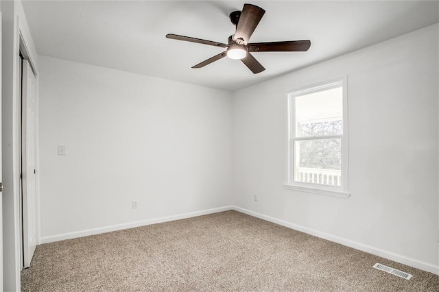 carpeted spare room with ceiling fan