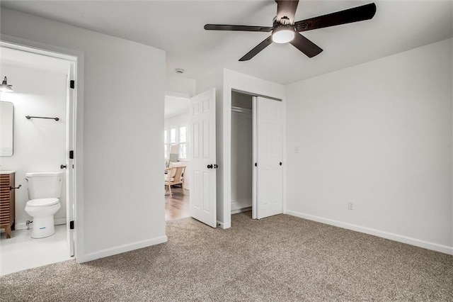 unfurnished bedroom featuring a closet, light colored carpet, ceiling fan, and ensuite bathroom