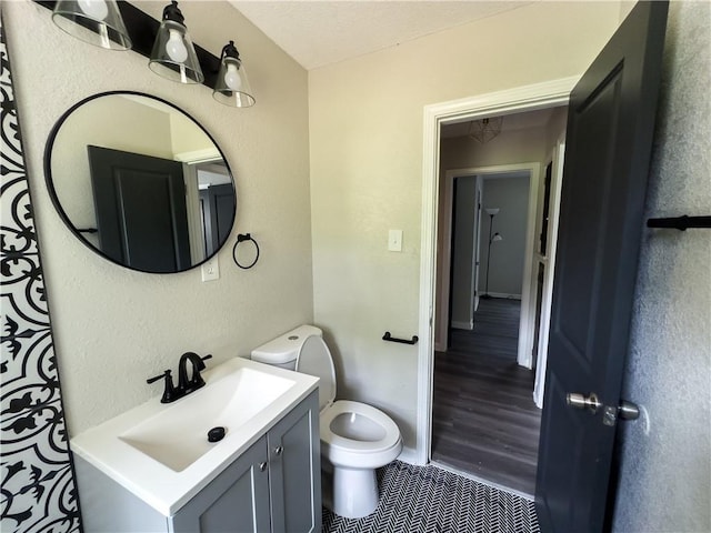 bathroom featuring vanity, hardwood / wood-style flooring, and toilet