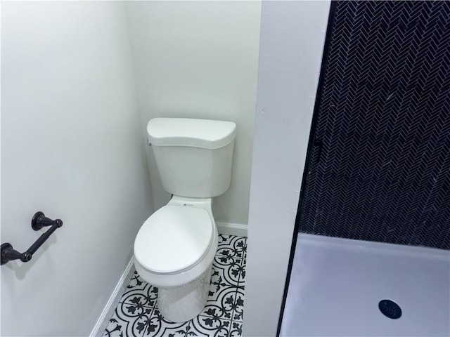 bathroom featuring tile patterned floors, toilet, and walk in shower