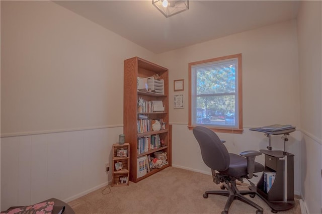 carpeted home office featuring wood walls