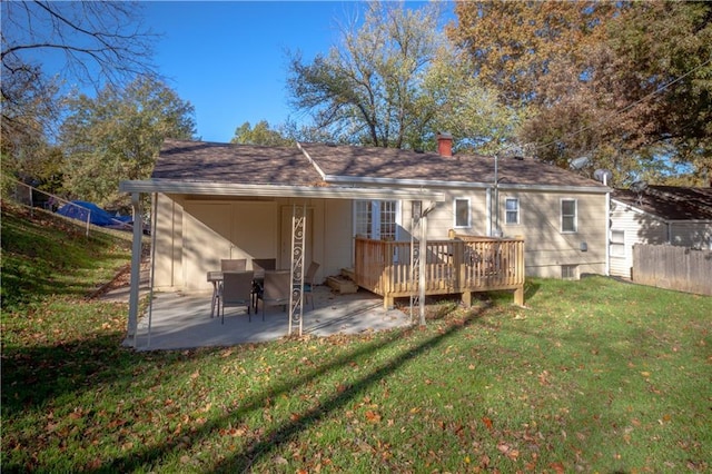 rear view of property with a yard, a patio, and a wooden deck