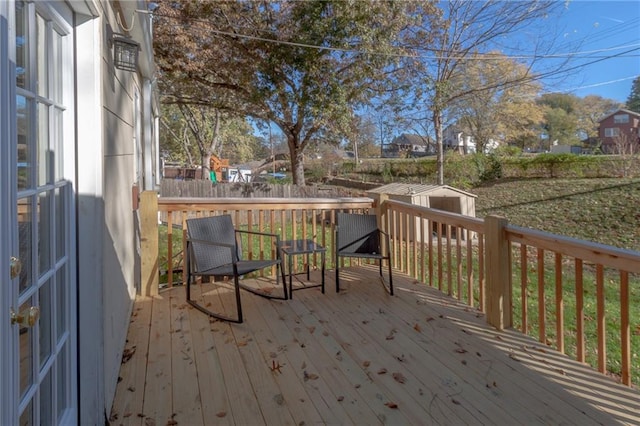 deck with a shed and a lawn