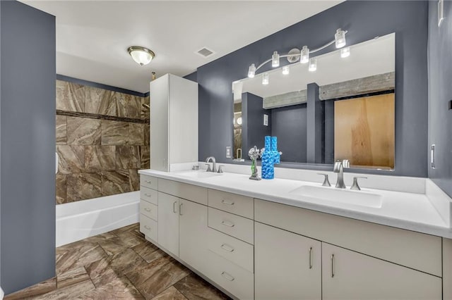 bathroom featuring vanity and tiled shower / bath