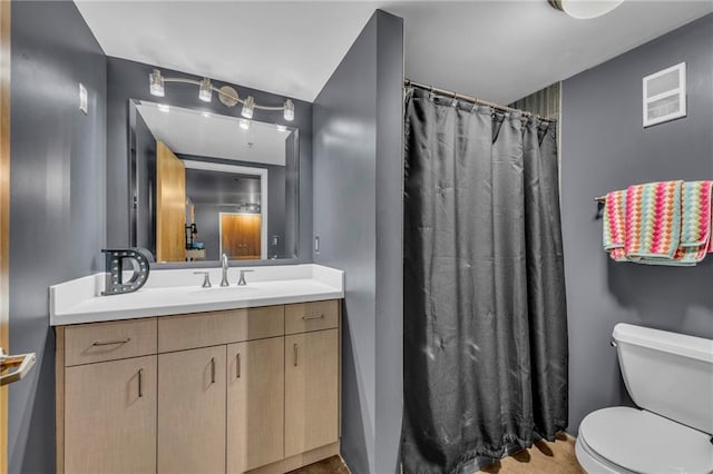 bathroom with vanity, toilet, and walk in shower