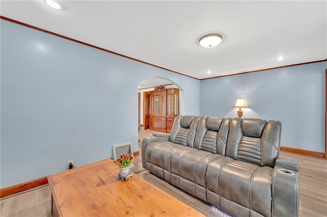 living room with light hardwood / wood-style flooring and crown molding