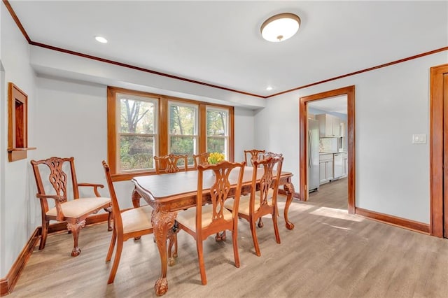 dining area with crown molding and light wood-type flooring