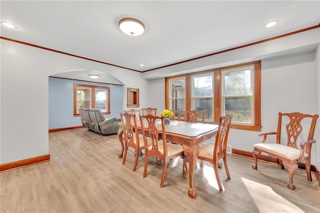 dining area featuring ornamental molding and light hardwood / wood-style flooring