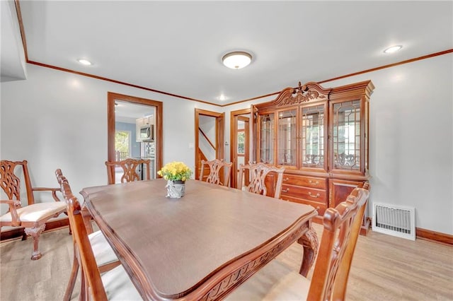 dining space featuring light hardwood / wood-style floors and ornamental molding