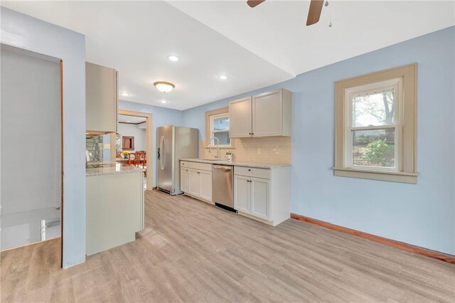 kitchen featuring light hardwood / wood-style flooring, tasteful backsplash, stainless steel appliances, and sink