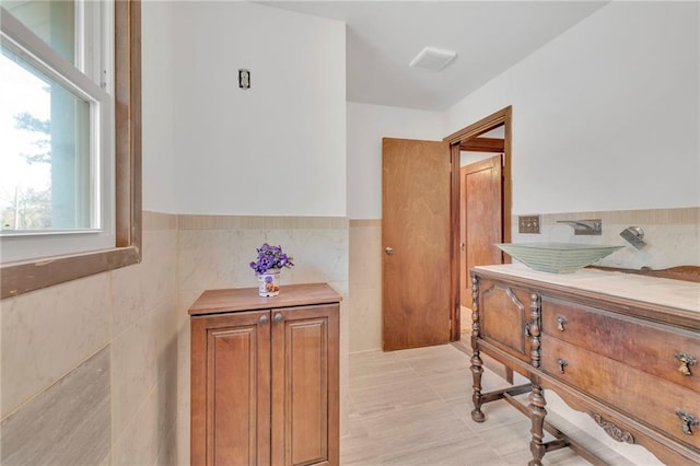 bathroom featuring sink and tile walls