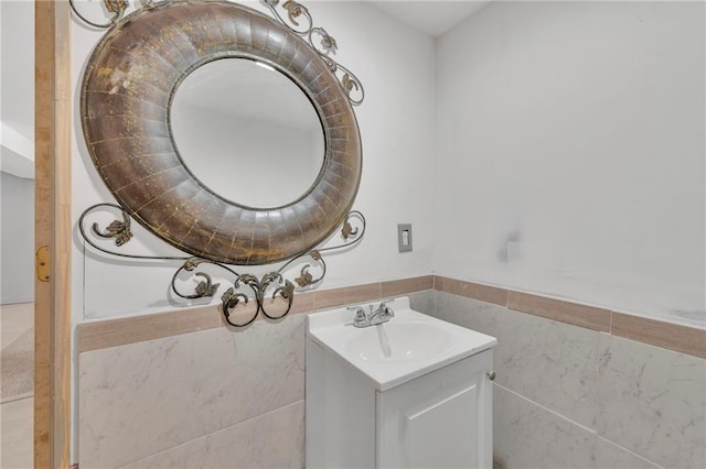 bathroom featuring vanity and tile walls