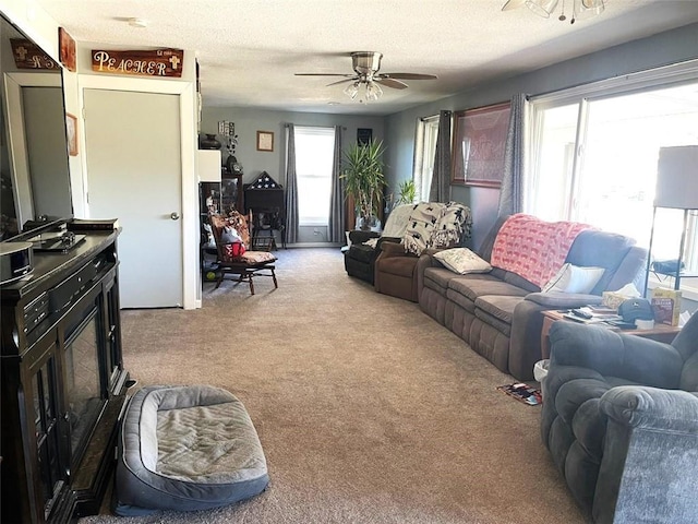 carpeted living room featuring a textured ceiling and ceiling fan