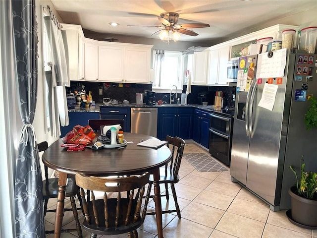 kitchen featuring blue cabinets, sink, decorative backsplash, and stainless steel appliances