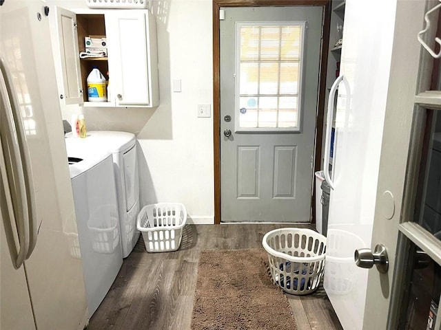 laundry area featuring cabinets, washer and dryer, and dark hardwood / wood-style flooring