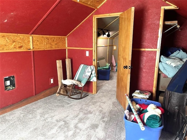 interior space with carpet flooring and vaulted ceiling