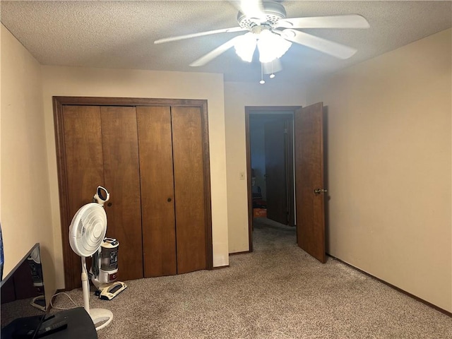 unfurnished bedroom featuring ceiling fan, a textured ceiling, a closet, and light colored carpet