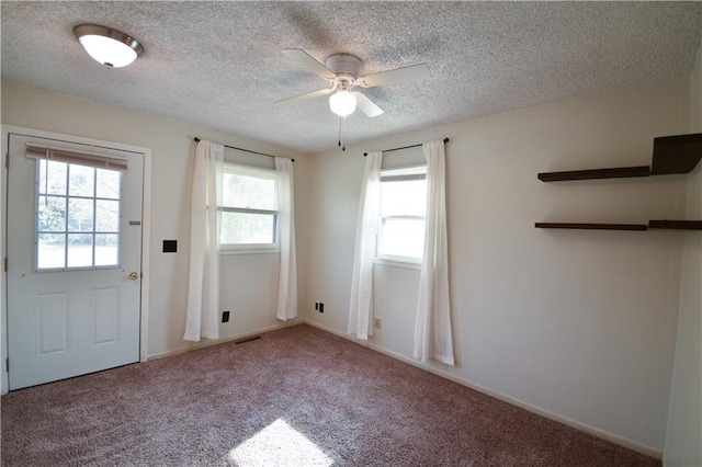 doorway featuring carpet floors, a textured ceiling, and ceiling fan