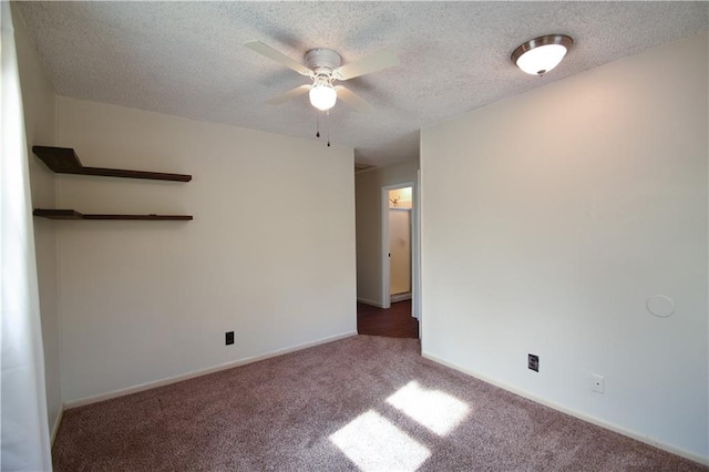 carpeted spare room featuring a textured ceiling and ceiling fan