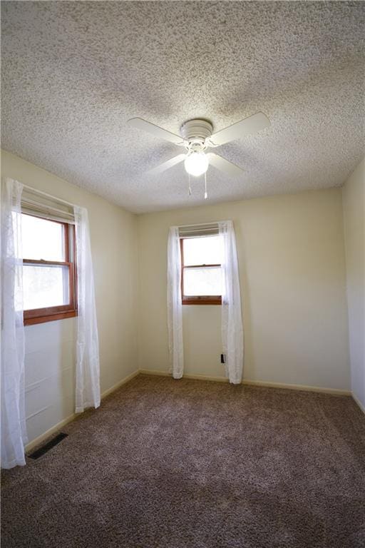 carpeted spare room with ceiling fan and a textured ceiling