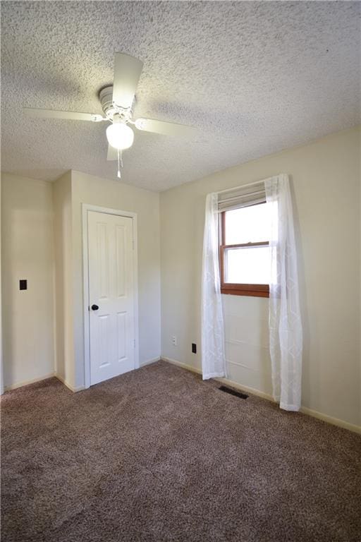 unfurnished bedroom featuring a closet, ceiling fan, carpet, and a textured ceiling