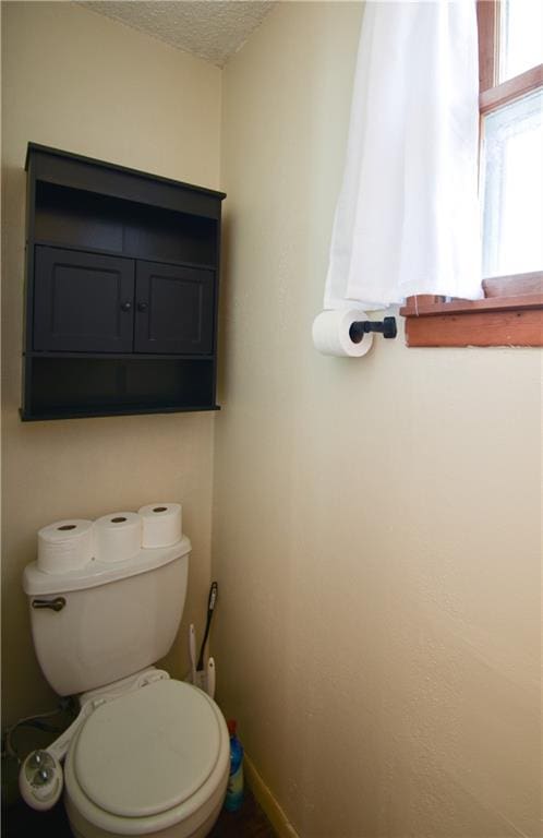 bathroom featuring a textured ceiling and toilet