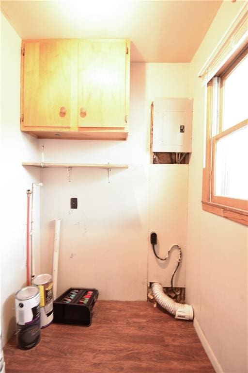 laundry area featuring cabinets, water heater, and hardwood / wood-style floors