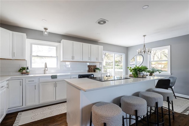 kitchen with pendant lighting, sink, and white cabinets