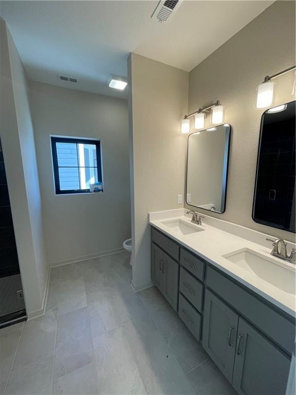 bathroom featuring vanity, tile patterned flooring, toilet, and walk in shower