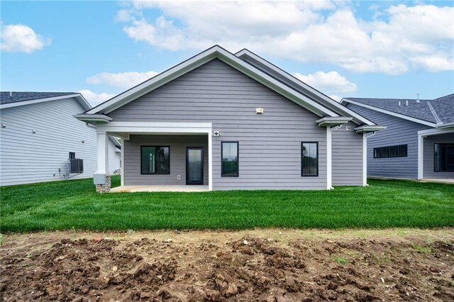 back of house featuring a lawn, a patio, and central air condition unit