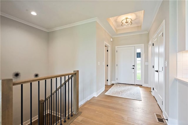 foyer with ornamental molding, light hardwood / wood-style flooring, and a notable chandelier