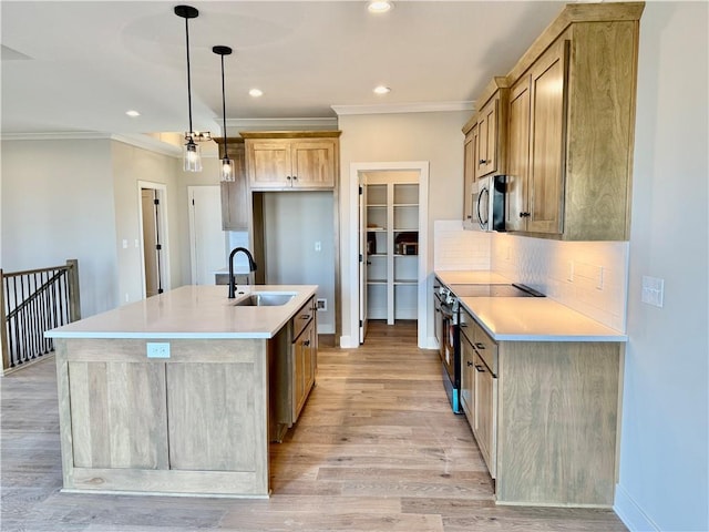 kitchen with appliances with stainless steel finishes, pendant lighting, sink, backsplash, and a kitchen island with sink