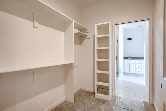 spacious closet with a sink and carpet flooring
