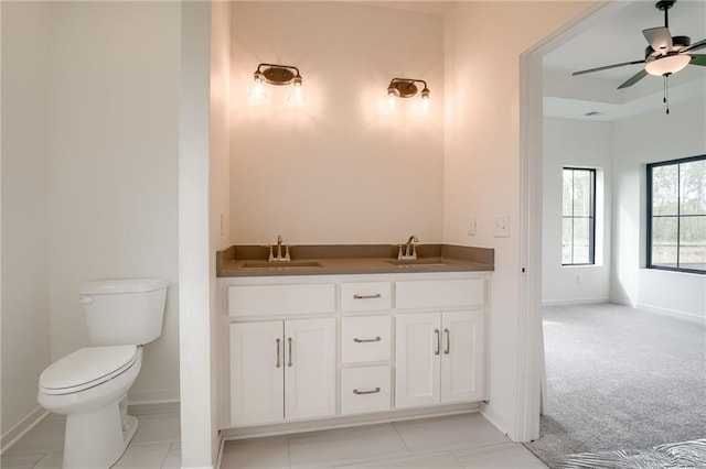 bathroom featuring a sink, baseboards, a ceiling fan, and toilet