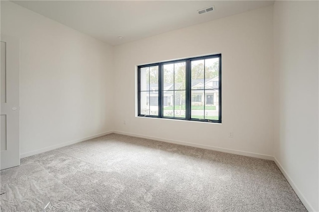 carpeted spare room with baseboards and visible vents