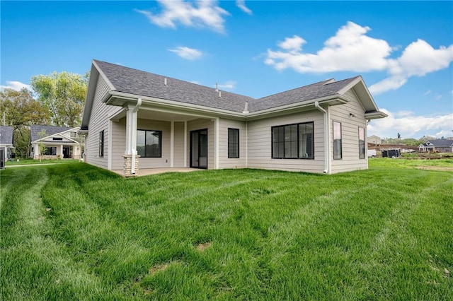 back of house with a patio and a yard